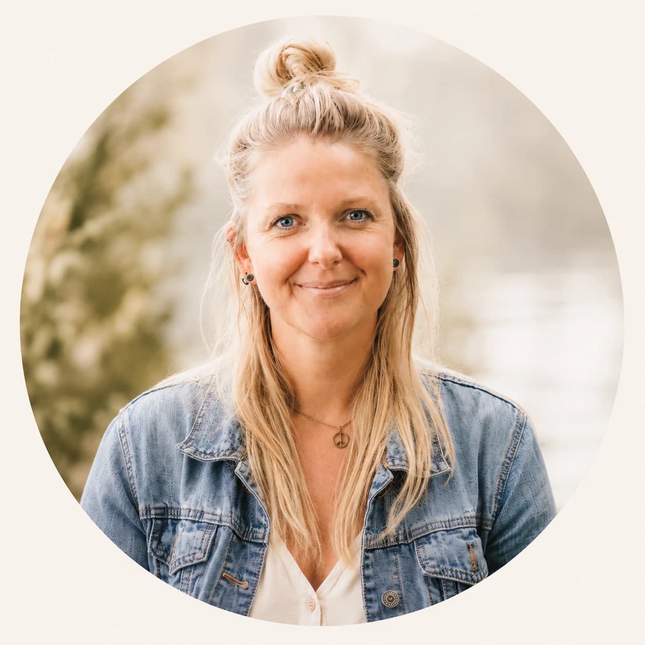 Jenny Heyden lächelt in die Kamera, im Hintergrund unscharfes Grün